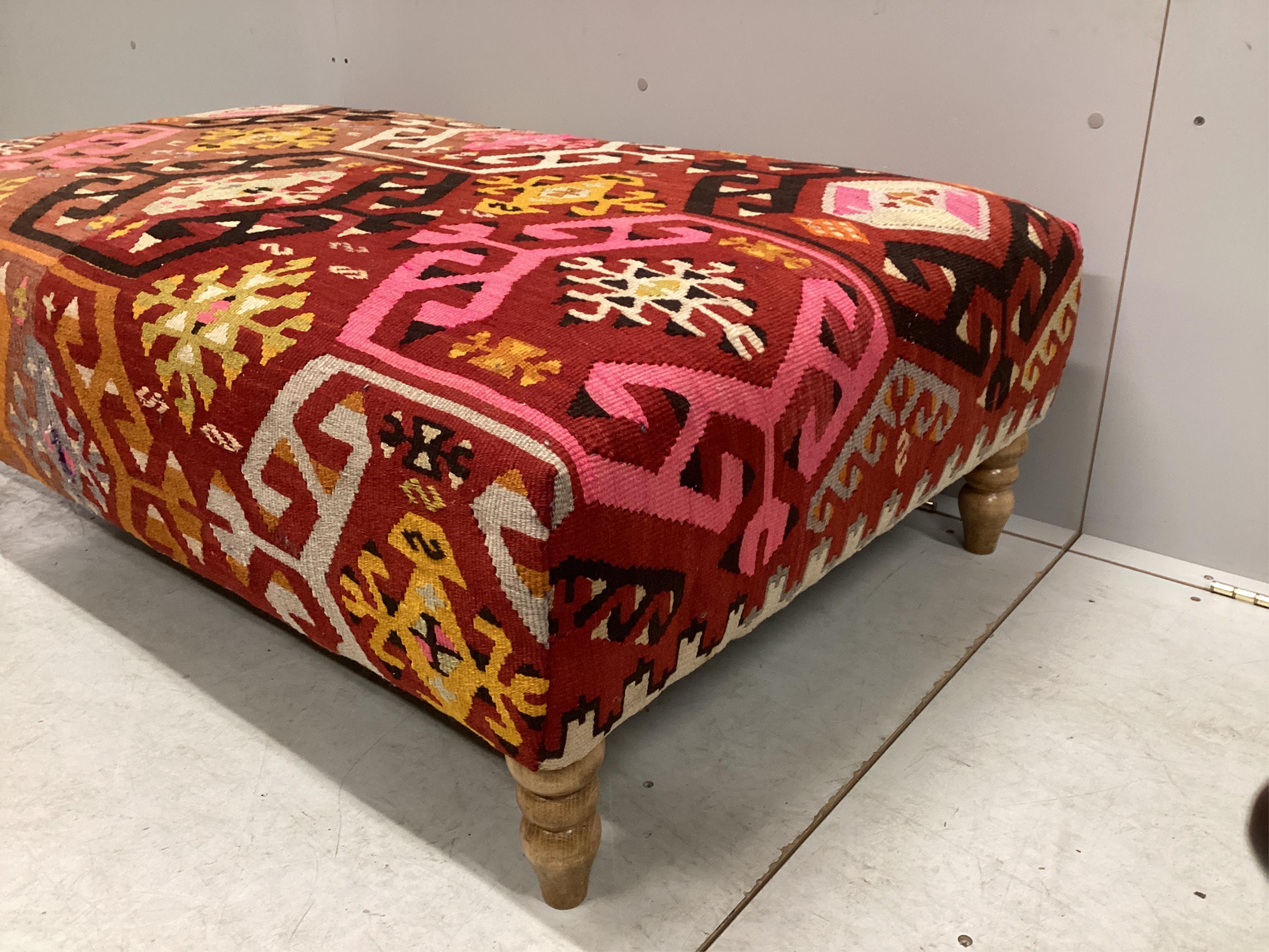 A large Contemporary rectangular footstool with antique polychrome Kilim upholstery on turned beech feet, width 124cm, depth 78cm, height 40cm